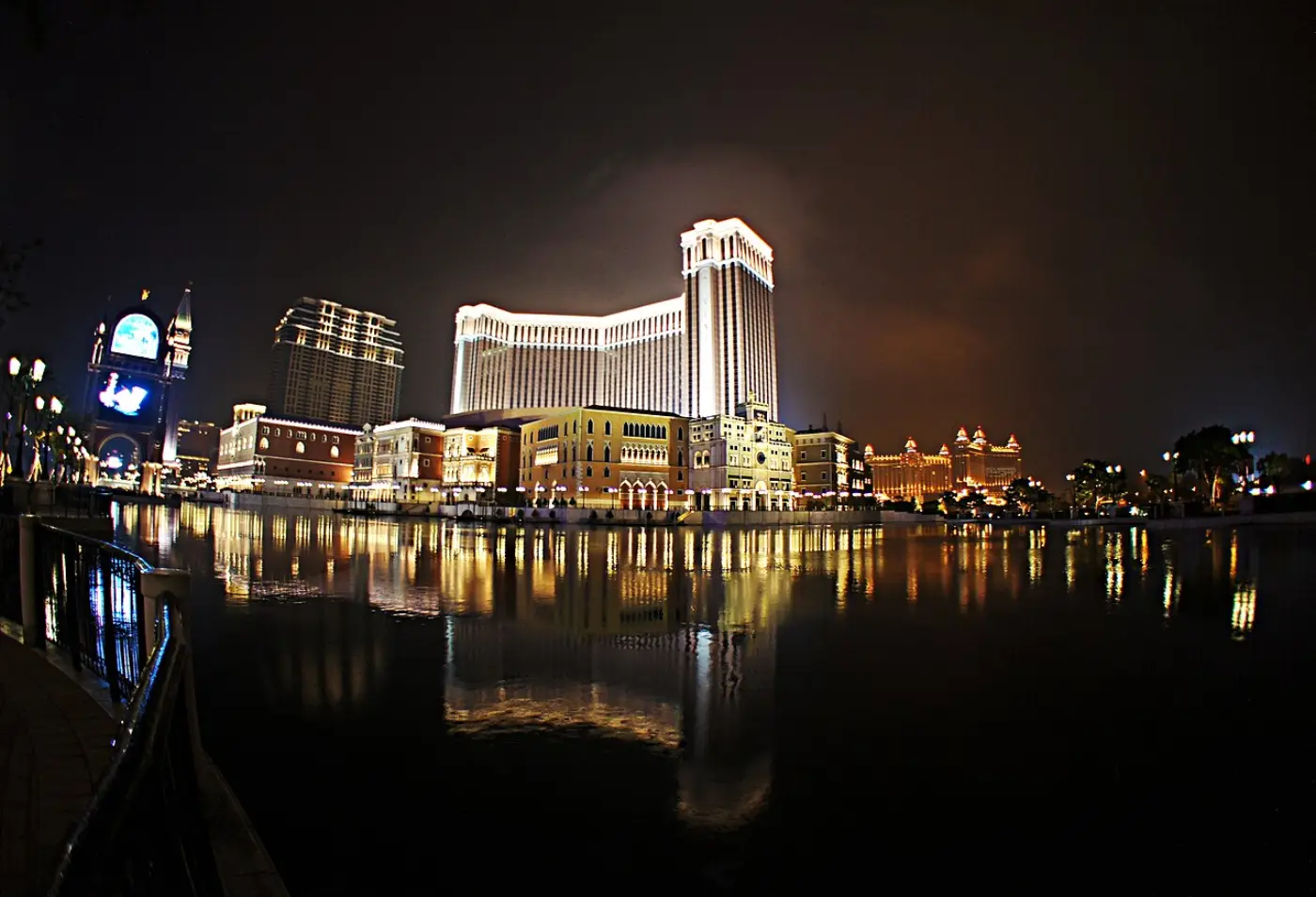 The Venetian Macao lit up after dark, its facade reflected in the water of the Cotai strip